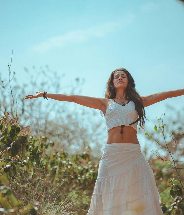 Woman performing a fluid yoga pose in a calm dark environment.